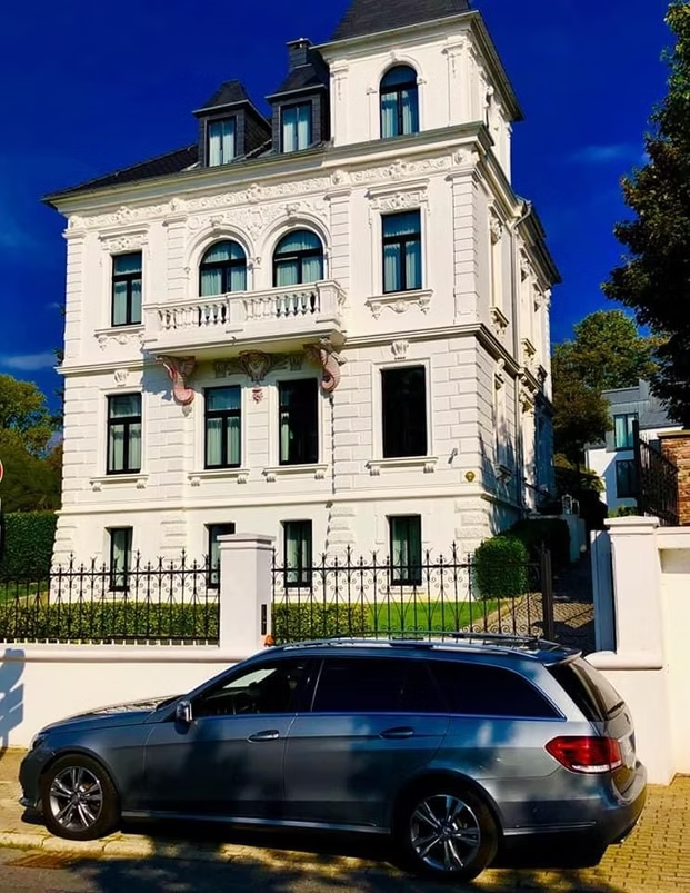 Mercedes vor repräsentativer Immobilie