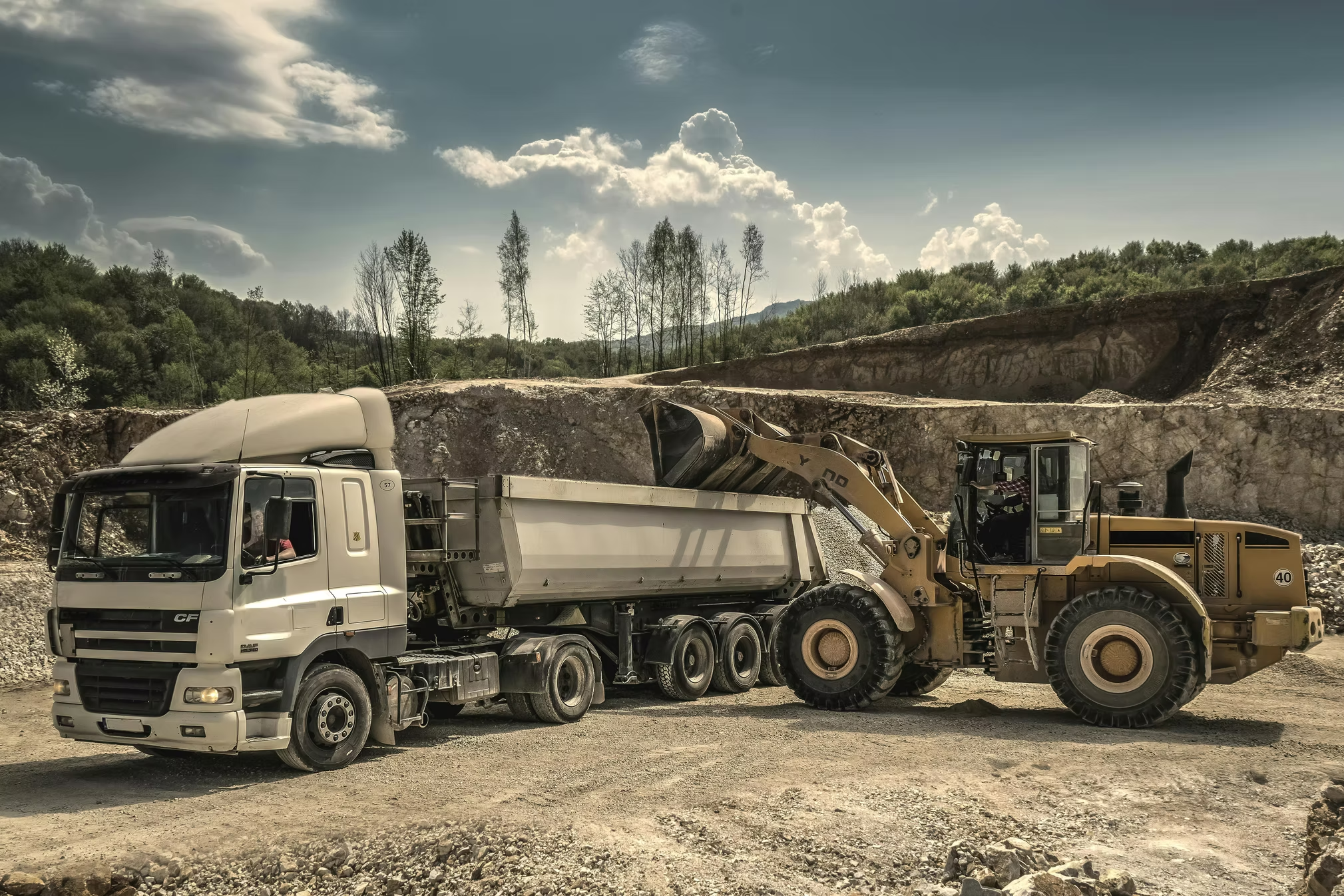 Radlader belädt LKW in einer Kies- oder Schottergrube